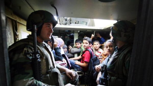 Lebanese army soldiers evacuate civilians caught in sniper fire in the Lebanese northern coastal city of Tripoli on November 30, 2013.  [AFP]