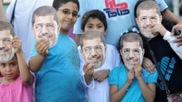 اطفال مع زويهم المؤيدين للرئيس المعزول في الاسكندرية عقب صلاة عيد الفطر/أ.ف.ب