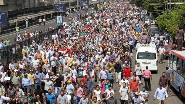 EGYPT, Cairo : Egyptian Muslim Brotherhood supporters walk in a street towards Ramses square in Cairo on August 16, 2013 as demonstrators gathered in support of Egypt's ousted president Mohamed Morsi. AFP PHOTO / KHALED KAMEL
