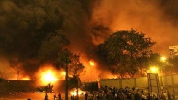 محتجون يقفون حول مقر الحزب الوطني الحاكم في القاهرة والذي اشتعلت فيه النيران