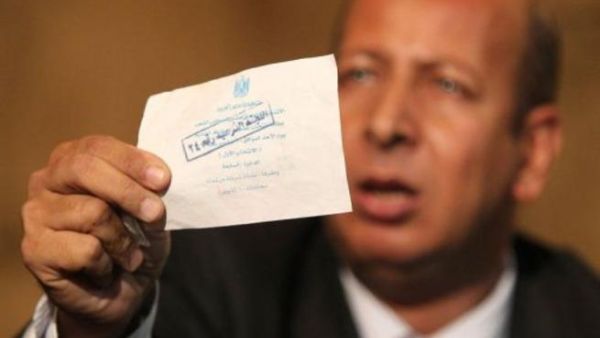 احد اعضاء حزب الوفد يحمل صوتا يقول حزبه انه مزور خلال مؤتمر صحافي في مقر الحزب في القاهرة الخميس