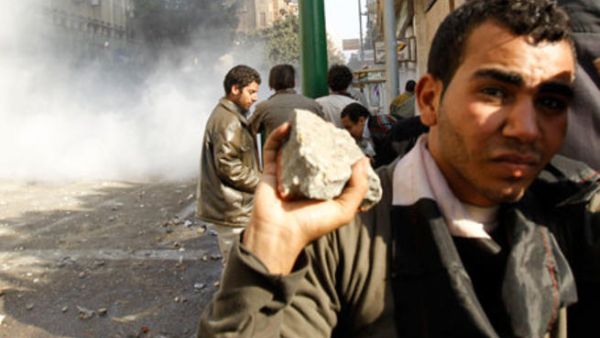 شاب يحمل حجارة خلال المصادمات في محيط ميدان التحرير