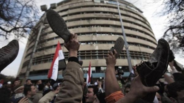 متظاهرون يرفعون احذيتهم امام مبنى التلفزيون المصري الوطني/الجمعة 11 فبراير/شباط/أ.ف.ب