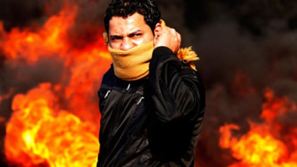 متظاهر يقف امام نيران مشتعلة في العاصمة المصرية