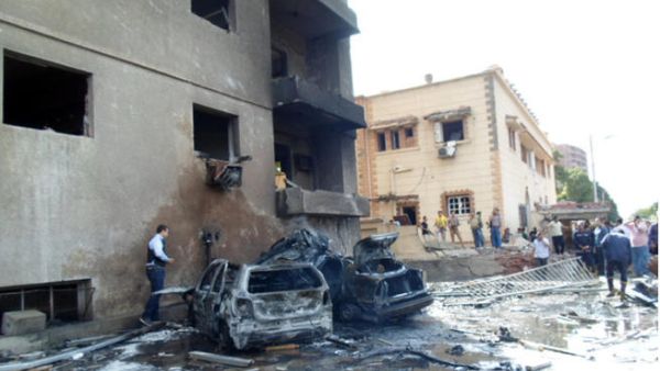 People look at burnt vehicles after a car bomb attack outside a military intelligence building. (Image credit: AFP)