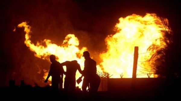 Egyptian security stand in the vicinity of flames following an attack by saboteurs on an Egyptian gas pipeline on July 12, 2011. [AFP]