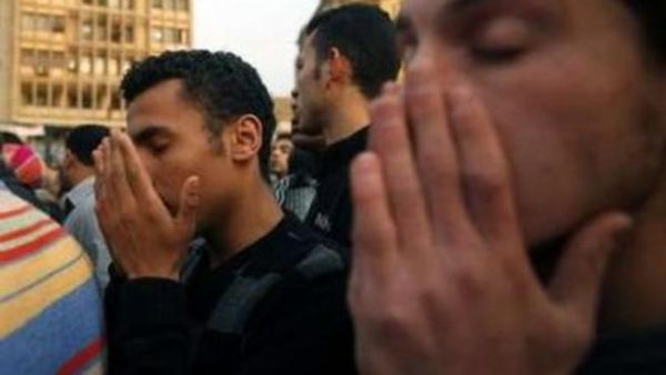 شبان مصريون في ميدان التحرير يقراون الفاتحة امام نصب للقتلى في احداث مصر