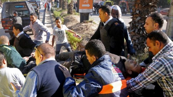 Egyptian emergency services carry a wounded victim at the site of a bomb attack next to a police checkpoint in the western Talibiya district of the capital Cairo on December 9, 2016. (AFP/Stringer)