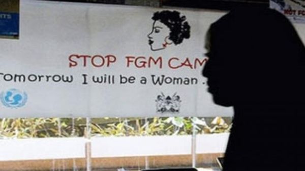 A woman walks past a poster from a campaign to stop FGM in Egypt. (AFP/File)