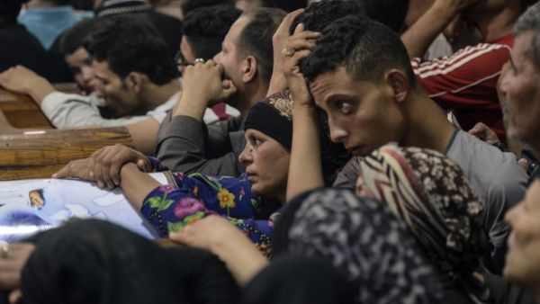 Relatives of killed Coptic Christians grieve by the coffins during the funeral at Abu Garnous Cathedral in the north Minya town of Maghagha, on May 26, 2017 (Mohamed El-Shahed/AFP)