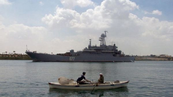 Egyptian fishermen row past a warship. (AFP/File)