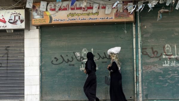 Women walk down a street in Syria's embattled Aleppo,  a former economic hub and home to priceless UNESCO-listed historical sites.  (AFP/Miguel Medina)