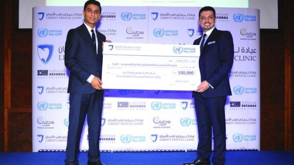 محمد عساف يتسلم شيك الأونروا من الدكتور مجد ناجي