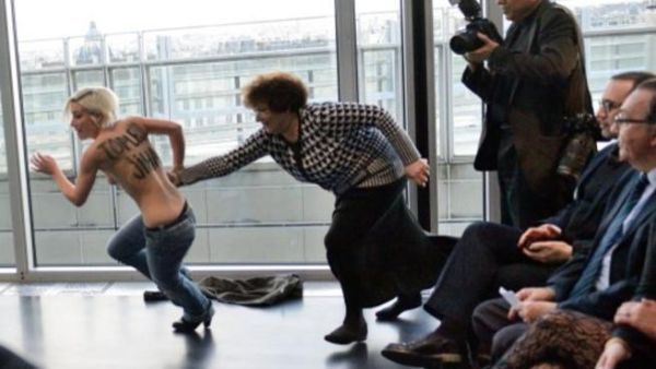 احدى عضوات جماعة فيمن تحاول اقتحام محاضرة للرئيس التونسي في باريس تضامنا مع "امينة"/أ.ف.ب