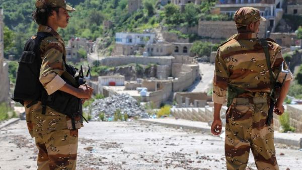 Fighters survey the ongoing damage in the Taez province. (AFP/Ahmad al-Basha)