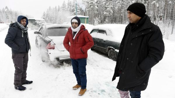 Asylum seekers from Afghanistan and Pakistan wait for permission on the Russian side of the border, near Kuoloyarvi to cross to the Salla border crossing of Finland, on January 23, 2016. (AFP/Jussi Nukari)