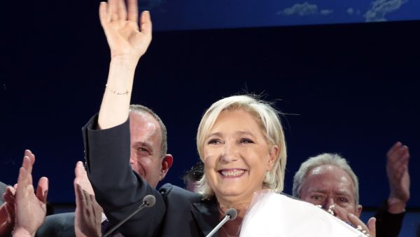 The audience sport red and blue National Front buttons and blue roses. The venue is a sea of French flags.(AFP) 
