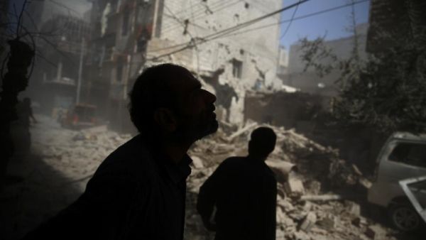 Locals examine the damage after airstrikes hit a rebel-controlled area of Douma, northeast of Damascus, on October 2, 2015.  (AFP/Abd Doumany)