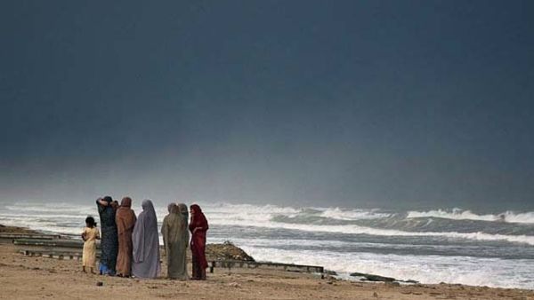Iranian women look out towards the water on the beach of the Caspian Sea.  (AFP/File) 