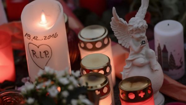A candle reading 'RIP' and the date of the Christmas market's attack stands next to an angel figure near the terror attack site in Berlin on December 21, 2016. (AFP/Clemens Bilan)
