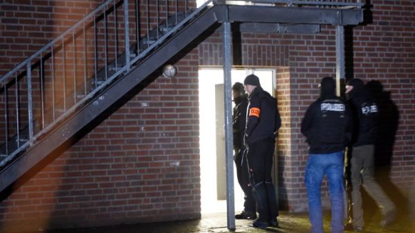 Policemen enter a home for asylum seekers in Emmerich, western Germany, on December 22, 2016. (AFP/Henning Kaiser)