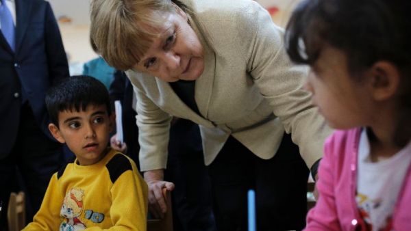 German Chancellor Angela Merkel talks with refugee children at a preschool, during a visit to a refugee camp in Turkey. [AFP]