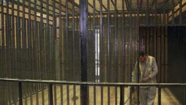 عامل نظافة يباشر عمله داخل قفص الاتهام الذي اعد لمحاكمة مبارك داخل اكاديمية الشرطة بالقاهرة 