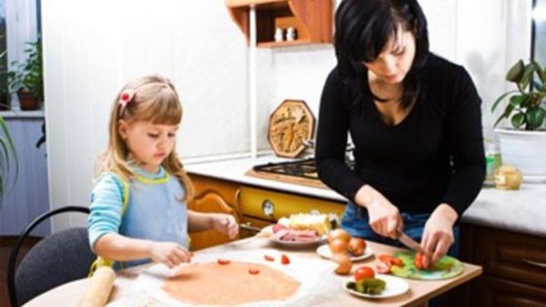 طفلة تساعد والدتها في تحضير بيتزا صحية طفلة تساعد والدتها في تحضير بيتزا صحية
