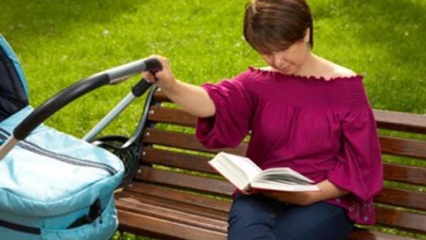 أم تحاول قراءة كتاب اثناء نوم رضيعها