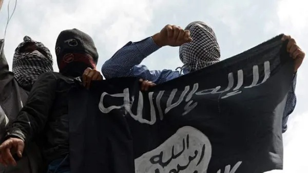 Daesh militants hold their flag on display. (AFP/File)
