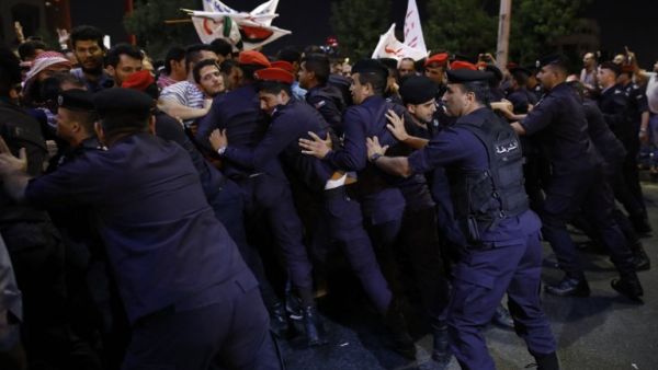 Demonstrators face Jordanian anti-riot police and security forces during a protest near the prime minister's office in Amman, Jordan, on June 5, 2018/AFP