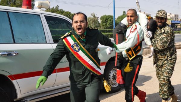 An Iranian soldier carrying an injured comrade at the scene of an attack on a military parade in Ahvaz on September 22. (AFP/File)