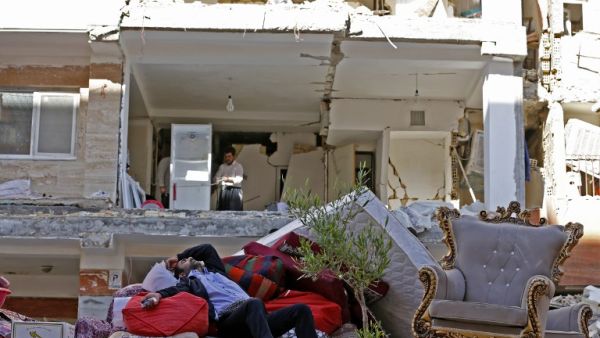 A man rests in the ruins of his home in Kermanshah province following Sunday's deadly earthquake (Atta Kenare/AFP)