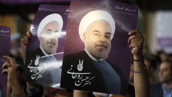 Supporters of Iranian presidential candidate Hassan Rouhani hold his portrait during a campaign rally in the capital Tehran on May 4, 2017. (AFP/Atta Kenare)
