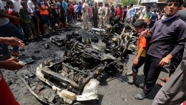 Iraqis gather at the scene of a car bombing in Sadr City in May. (AFP/File)