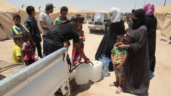 Iraqis who fled fighting between government forces and Daesh in Fallujah fill jerrycans with water at a camp for displaced people in Amriyat al-Fallujah on June 14, 2016. (AFP/Sabah Arar)