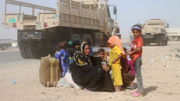 Iraqis displaced from al-Buthiab area north of Ramadi sit on the side of a street after arriving at a makeshift camp on June 25, 2016. (AFP/Moadh al-Dulaimi)