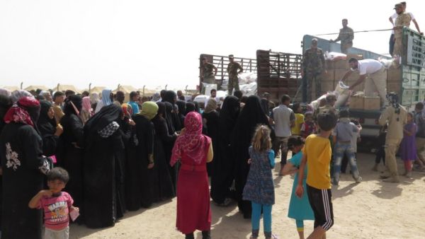 Displaced Iraqi families, who fled their homes in Fallujah due to fighting between Iraqi government forces and Daesh, queue for food rations and other emergency supplies on June 6, 2016. (AFP/Ahmad Mousa)
