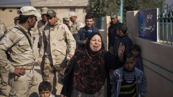 An Iraqi woman who had fled the fighting is pleading with the soldiers as her son is being questioned by the Iraqi army 9th armoured division at an operating base adjacent to the Al-Intissar neighbourhood of Mosul on November 7, 2016. (AFP/Odd Andersen)