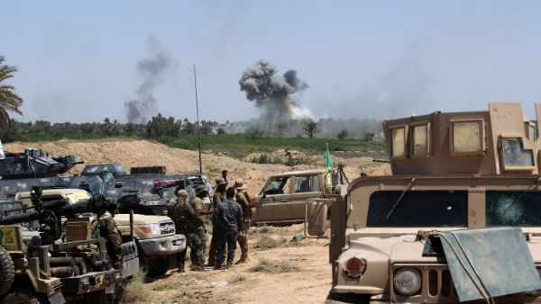 Iraqi government forces advance near al-Sejar village, north-east of Fallujah, as smoke billows in the background on May 26, 2016, as they take part in a major assault to retake the city from the Islamic State (IS) group. (AFP/Ahmad al-Rubaye)