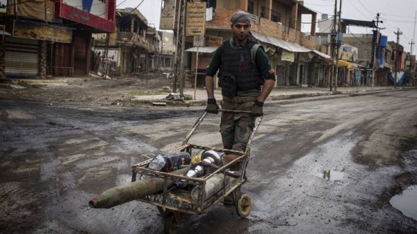 A Christian militia fighter from the Nineveh Plain Protection Units (NPU) pushes a trolley carrying a rocket in a street in Qaraqosh, some 30 kilometres east of Mosul on December 20, 2016. (AFP/JM Lopez)