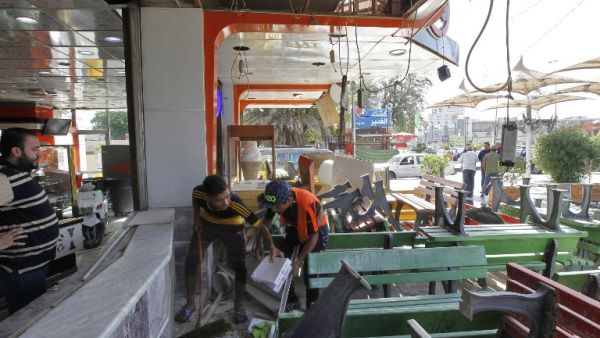 Iraqis check an ice cream shop in Baghdad's Karrada district in the aftermath of a car bomb explosion on May 30, 2017. (Sabah Arar/AFP)