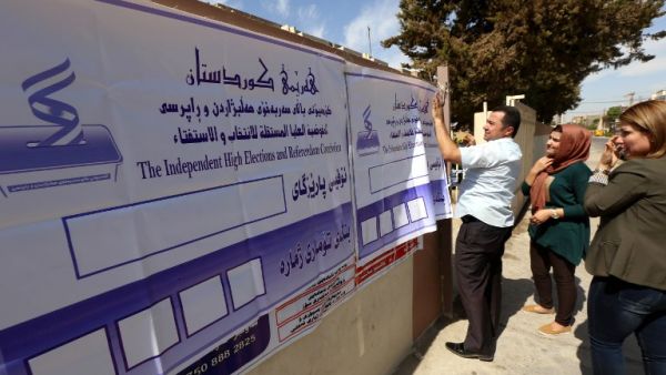 Poster are put up at a polling station in Irbil ahead of the Kurdish independence referendum (Safin Hamed/AFP)
