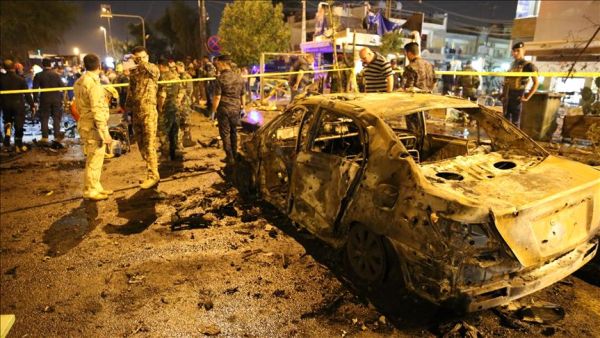 People gather around the incident site as security forces cordon the area after a road-side parked car-bomb attack in Karrada district of Baghdad, Iraq on May 29, 2017. (AFP/Mehmet Hapitoglu)