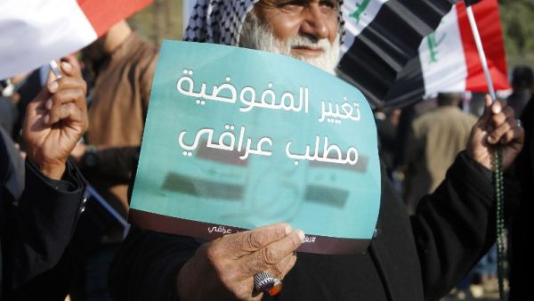  "Iraqis demand change to the electoral commission", protester holds up a sign during Wednesday's protest (Sabah Arar/AFP)