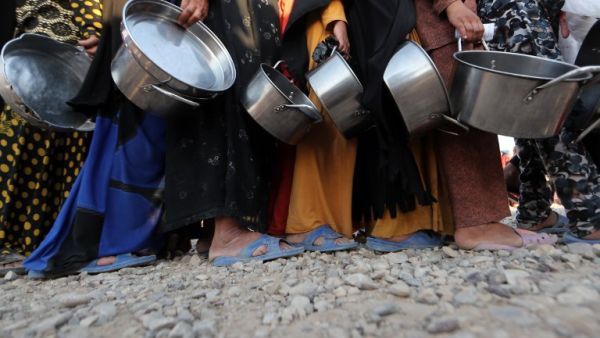 Displaced Iraqis receive aid food during the Muslim holy month of Ramadan at al-Khazir camp for the internally displaced, located between Arbil and Mosul, on June 5, 2017. The camp was hit by a mass outbreak of food poisoning on June 12. (Karim Sahib/AFP)