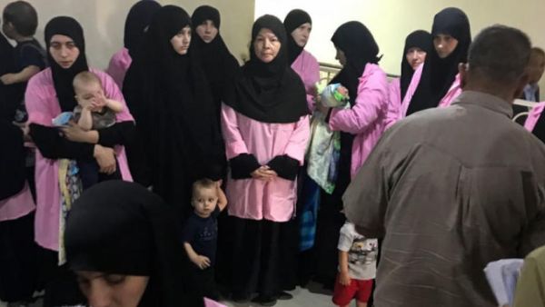 Baghdad's Central Criminal Court shows women who have been sentenced to life in prison on grounds of joining ISIS standing with their children in a hallway. (Ammar Karim / AFP)