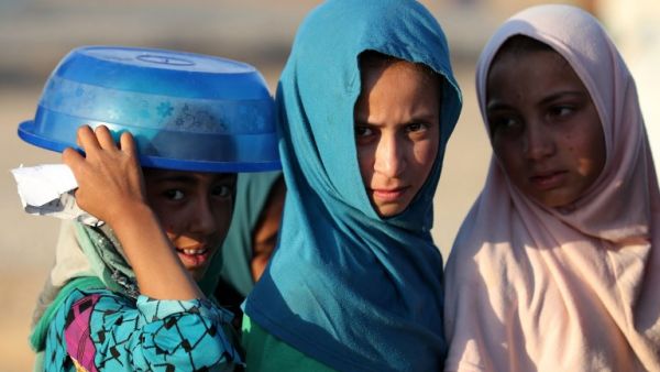 Displaced Iraqis receive aid food during the Muslim holy month of Ramadan at al-Khazir camp for the internally displaced, located between Arbil and Mosul, on June 5, 2017. (AFP/Karim Sahib)