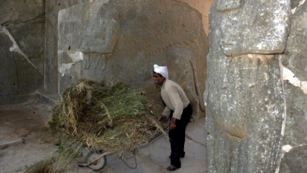 An Iraqi worker cleans up the archaeological site of Nimrud, south of Mosul in northern Iraq, 21 April 2001. (AFP/File) 