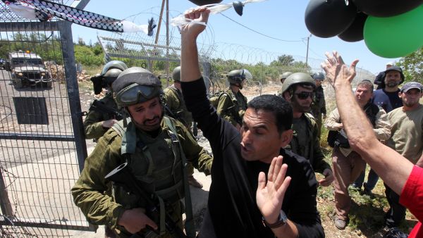 Palestinian protesters are stopped by Israeli soldiers during a protest against settlement expansion on Palestinian land. [vosizneias]